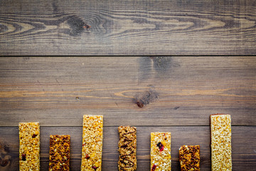 Granola bars for healthy nutritious breakfast on dark wooden background top view copy space pattern