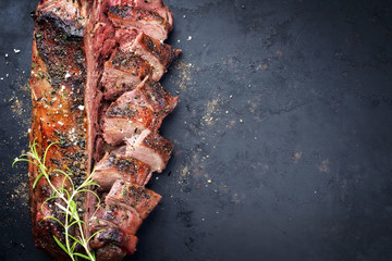 Traditional barbecue aged saddle of venison marinated as top view on an old rustic board with copy...