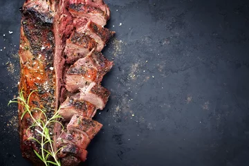  Traditional barbecue aged saddle of venison marinated as top view on an old rustic board with copy space right © HLPhoto