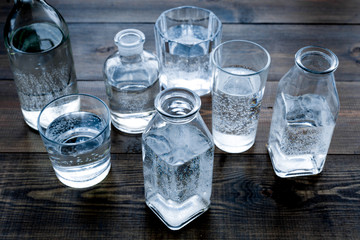 Drinks on the table. Pure water in jar and glasses on dark wooden background