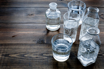 Drinks on the table. Pure water in jar and glasses on dark wooden background space for text