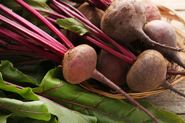 Fresh and ripe beets in basket on wooden table