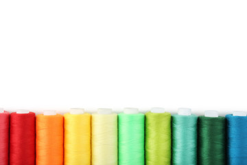 Colourful thread spools on white background
