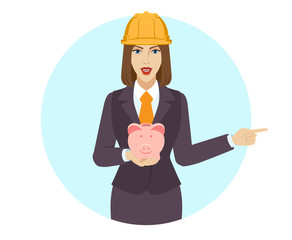 Businesswoman holding a piggy bank and pointing something beside of her