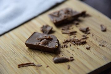 Cracked chocolate pile on dark background with shallow depth of field