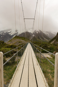 Suspension bridge and wooden path in to national park New Zealand natural landscape background