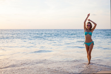 Woman in bikini dancing in the sea