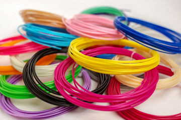 Group of colourful  ABS and PLA plastic filament for 3D printer and pen on white background
