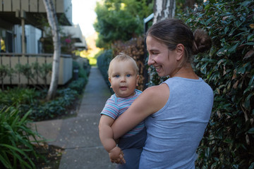Fototapeta premium A mother with baby son in green neighborhood