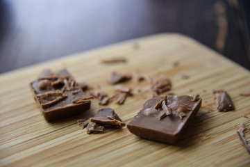 Cracked chocolate pile on dark background with shallow depth of field