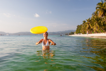 Woman plays frisbee in the water of beautiful ocean