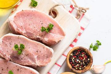 Pork meat steak on white top view. 