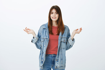 Girl struck with confusing question. Portrait of unaware hesitating girlfriend in trendy denim...