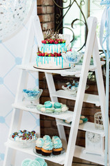 cake decorated with fruits and sweets lay on the shelves in the cafe