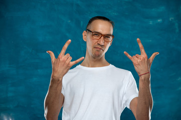 Portrait of young stylish hipster guy wearing glasses looking at the camera on blue background