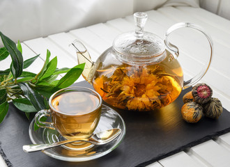 Exotic green tea with flowers in glass teapot