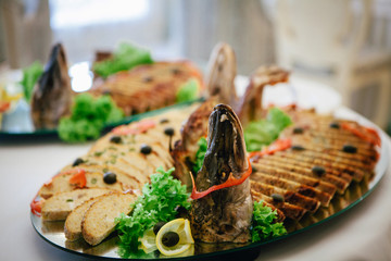dish of stuffed pike with lemon and greens is laying on the wedding table