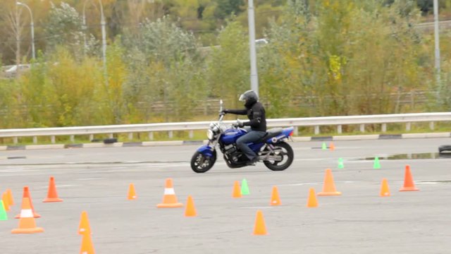 Motorcycle events, motorcycle rider at speed runs a line of road cones