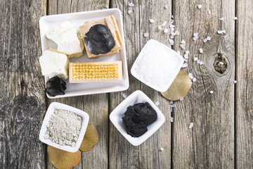 massage spa setting: cosmetic clay, mud, shea butter, organic soaps, bath salt, brush on old wood...