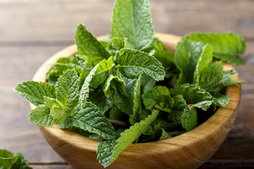 Fresh mint in a plate on a wooden background