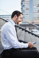 Junger Business Mann tippt eine SMS