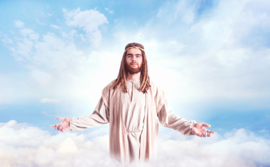 Fototapeta na wymiar Jesus Christ with open arms against cloudy sky