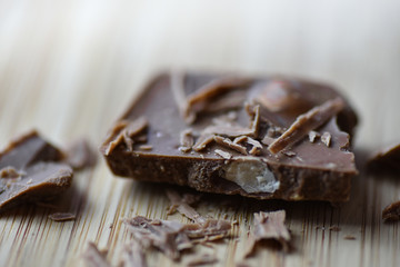 Cracked chocolate pile on dark background with shallow depth of field