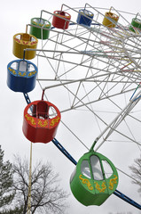 Ferris wheel in empty early spring park isolated on sky background