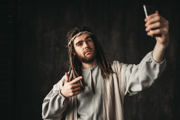 Man in the image of Jesus Christ makes selfie