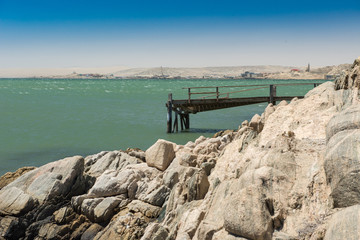 Felsen und ein alter Bootssteg vor der Stadt Lüderitz, Namibia