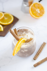 Chocolate-vanilla mousse with an orange slice on a white marble table