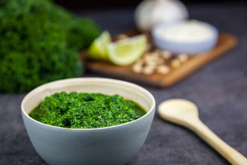 Pesto from kale. Kale, cheese, lemon, pine nuts and garlic on the background