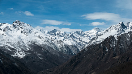 Fototapeta na wymiar Panoramic view of high mountain peaks and snowcapped ridges at high altitude in the Alps