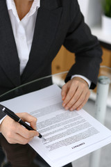 Close-up of female hands with pen over document,  business concept