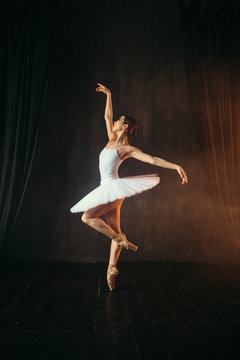 Ballerina in white dress and pointe shoes dancing