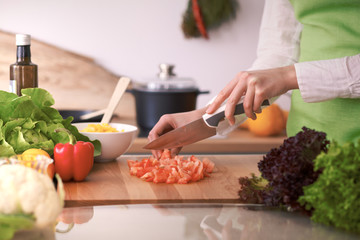 Close Up of human hands cooking vegetable salad in kitchen on the glass table with reflection. Healthy meal, and vegetarian food concept