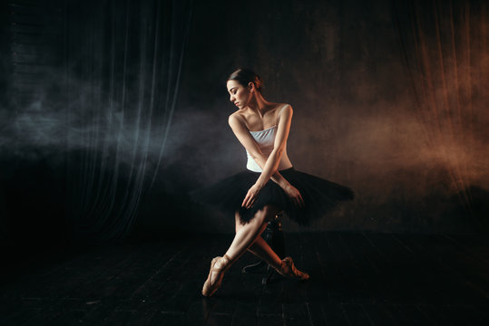 Ballet dancer sitting on black banquette