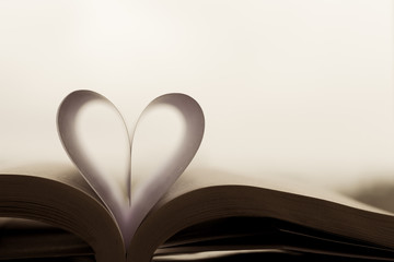 Heart-shaped paper inside a book. The heart is the symbol of love.