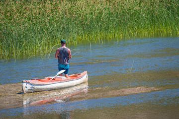 ein Sportangler fischt in einem Boot auf dem Orange River, Südafrika, Namibia