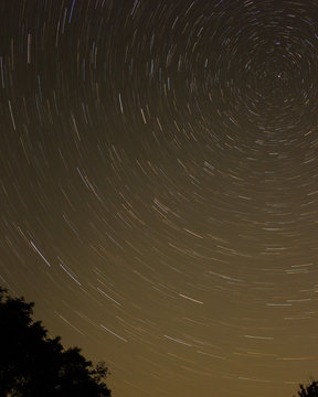 Night sky with spiral star trails around Pole star.