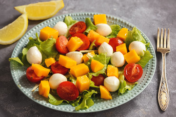 Salad with mango, tomatoes, mozzarella and lemon.