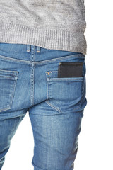 A man standing with his back in jeans with a leather black purse in his back pocket