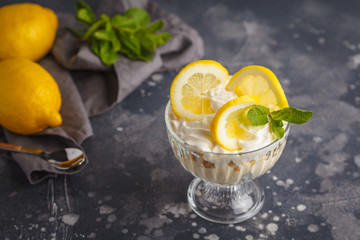 Lemon dessert. English lemon trifle, cheesecake, whipped cream, parfait. Fruit mousse in glass on a...