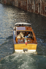 Fototapeta na wymiar Water taxi a canal in Venice, Italy, 2016