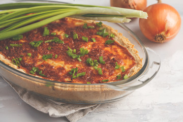 Traditional French onion pie. Quiche lorraine with onion, cheese and eggs in a glass oven dish.