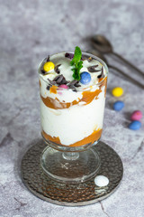 White chocolate ice cream and caramel dessert garnished with chocolate eggs and fresh mint