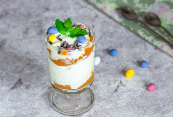 White chocolate ice cream and caramel dessert garnished with chocolate eggs and fresh mint