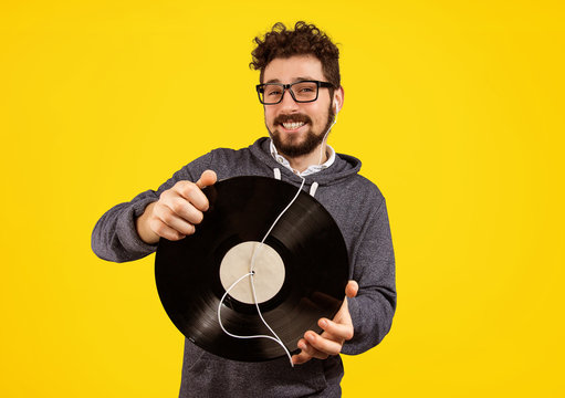 excited hipster man with vinyl record and earphones