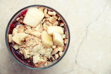 Delicious dessert with banana and biscuits chocolate pudding in glass cup on table top view