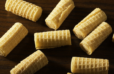 waffle rolls on the dark wooden surface.